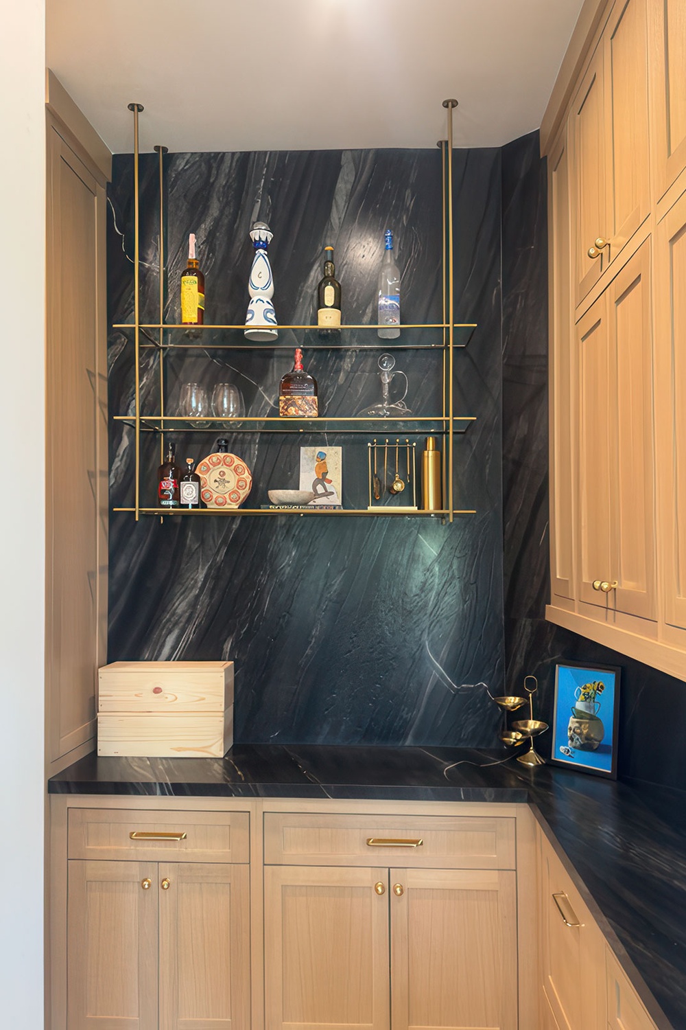 Dark soapstone-look countertop and full stone wall in a butler's pantry bar nook with white oak cabinets, Richmond VA
